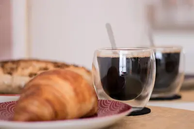 a glass of wine next to a plate of bread at Le Boho Chic Studio Cosy in Narbonne
