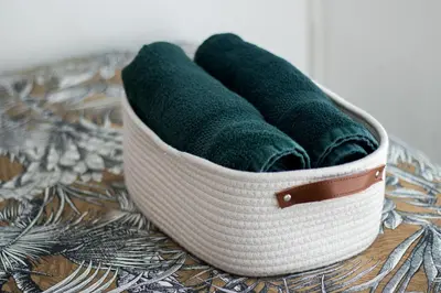 a basket of green towels sitting on a table at Le Boho Chic Studio Cosy in Narbonne