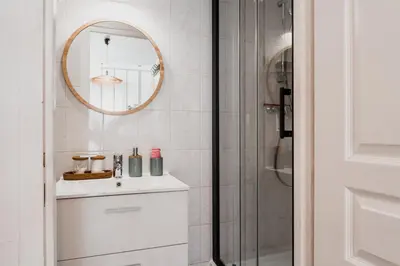 a white bathroom with a sink and a mirror at Le Boho Chic Studio Cosy in Narbonne