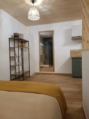 a bedroom with a bed and a wooden floor at Studio dans le Minervois in Bize-Minervois