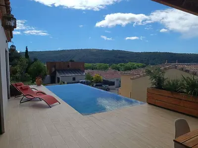 a swimming pool with two chairs on a patio at Studio dans le Minervois in Bize-Minervois