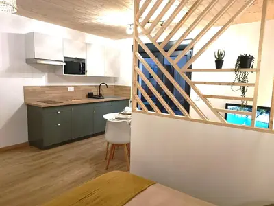 a kitchen with a staircase leading up to a loft at Studio dans le Minervois in Bize-Minervois
