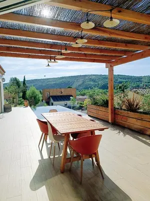 a wooden table and chairs on a patio at Studio dans le Minervois in Bize-Minervois