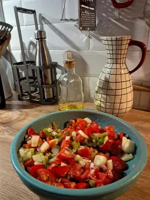 a bowl of vegetables on a table with a bottle at Chez Estelle Le SOL in Tourouzelle