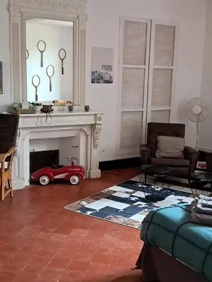 a living room with a red toy car in the fireplace at Chez Estelle Le SOL in Tourouzelle