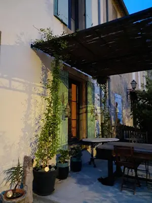 an outdoor patio with a table and potted plants at Chez Estelle Le SOL in Tourouzelle
