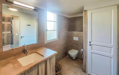 a bathroom with a sink and a toilet and a mirror at Awesome Home In Saint-Laurent-De-La-Ca With Wifi in Saint-Laurent-de-la-Cabrerisse
