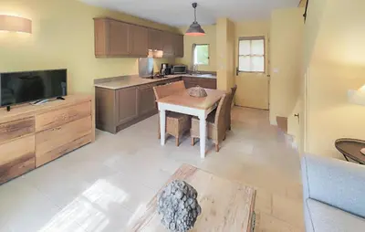 a kitchen with a small table and a kitchen with a tv at Awesome Home In Saint-Laurent-De-La-Ca With Wifi in Saint-Laurent-de-la-Cabrerisse