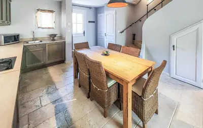 a kitchen and dining room with a wooden table and chairs at 2 Bedroom Awesome Home In Saint-Laurent-De-La-Ca in Saint-Laurent-de-la-Cabrerisse