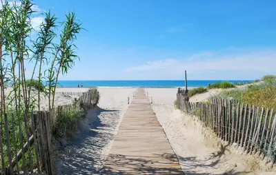 a wooden path to the beach with the ocean in the background at 2 Bedroom Awesome Home In Saint-Laurent-De-La-Ca in Saint-Laurent-de-la-Cabrerisse