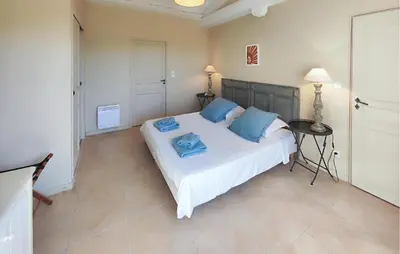 a bedroom with a large white bed with blue pillows at Amazing Home In Saint-Laurent-De-La-Ca in Saint-Laurent-de-la-Cabrerisse