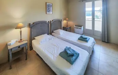 a bedroom with two beds and a table with a lamp at Amazing Home In Saint-Laurent-De-La-Ca in Saint-Laurent-de-la-Cabrerisse