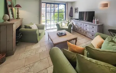 a living room with green chairs and a television at Amazing Home In Saint-Laurent-De-La-Ca in Saint-Laurent-de-la-Cabrerisse