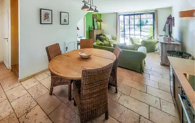 a kitchen and living room with a wooden table and chairs at Amazing Home In Saint-Laurent-De-La-Ca in Saint-Laurent-de-la-Cabrerisse