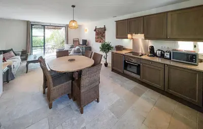 a kitchen with a table and chairs and a living room at 2 Bedroom Awesome Home In Saint-Laurent-De-La-Ca in Saint-Laurent-de-la-Cabrerisse