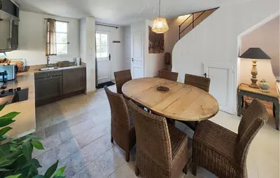 a kitchen and dining room with a wooden table and chairs at 2 Bedroom Awesome Home In Saint-Laurent-De-La-Ca in Saint-Laurent-de-la-Cabrerisse