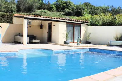 a villa with a swimming pool in front of a house at Gîte Les Amandiers in Villedubert