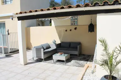 a patio with a couch and a table on a house at Gîte Les Amandiers in Villedubert