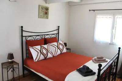 a bedroom with a bed with orange and white pillows at Gîte Les Amandiers in Villedubert