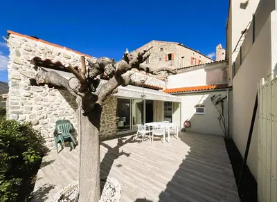 a view of a house with a wooden deck at La Caseta de Molitg in Molitg les Bains