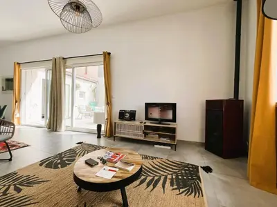 a living room with a table and a tv at La Caseta de Molitg in Molitg les Bains