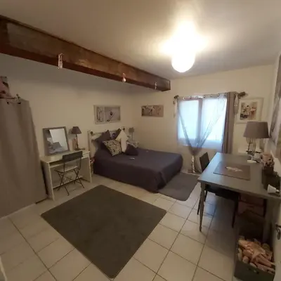a bedroom with a bed and a desk and a table at Belle demeure de charme in Montels
