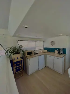 a kitchen with white cabinets and a potted plant at Bateau Mama Mia in Narbonne