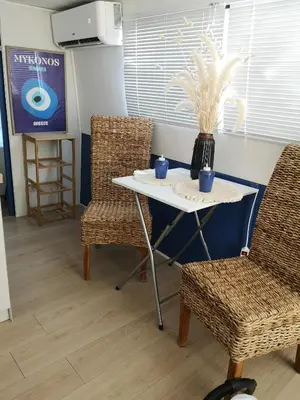 a table with two chairs and a vase on it at Bateau Mama Mia in Narbonne