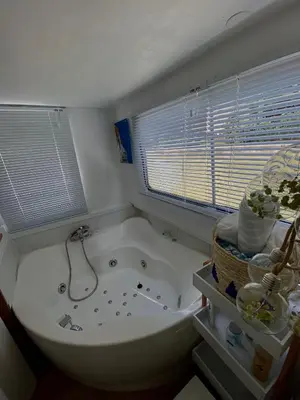 a bathroom with a tub and a toilet and a window at Bateau Mama Mia in Narbonne