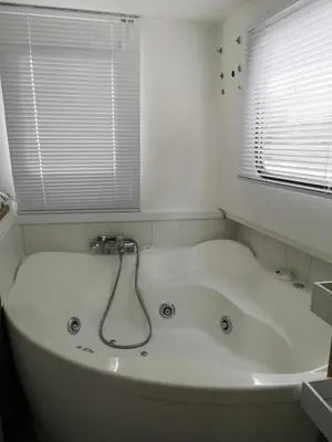 a white bath tub in a bathroom with a window at Bateau Mama Mia in Narbonne
