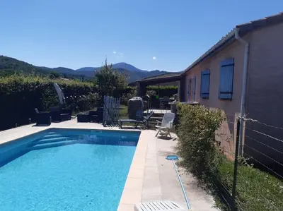 a swimming pool in a yard with a house at Villa calme avec piscine in Lavelanet