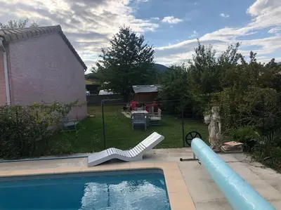 a swimming pool with a slide and a pool noodle at Villa calme avec piscine in Lavelanet