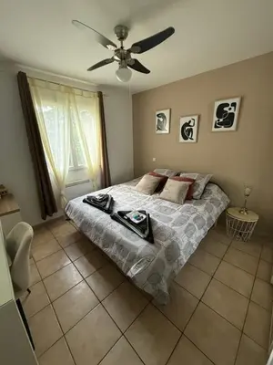 a bedroom with a bed and a ceiling fan at Villa calme avec piscine in Lavelanet