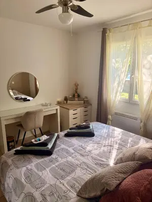 a bedroom with a bed with a desk and a mirror at Villa calme avec piscine in Lavelanet