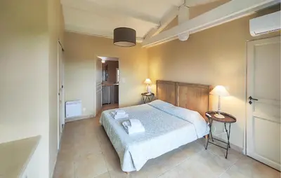a bedroom with a bed and two tables with lamps at Nice Home In Saint-Laurent-De-La-Ca in Saint-Laurent-de-la-Cabrerisse