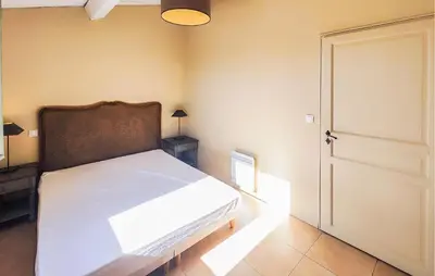a bedroom with a white bed and a door at 2 Bedroom Gorgeous Home In Saint-Laurent-De-La-Ca in Saint-Laurent-de-la-Cabrerisse