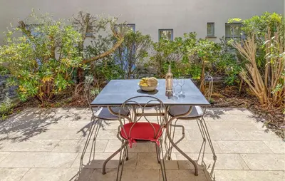 a blue table with two chairs and a bottle of wine at 2 Bedroom Lovely Home In Saint-Laurent-De-La-Ca in Saint-Laurent-de-la-Cabrerisse
