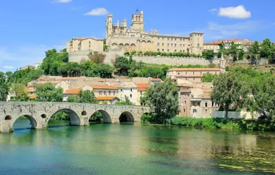 a bridge over a river with a castle in the background at 2 Bedroom Lovely Home In Saint-Laurent-De-La-Ca in Saint-Laurent-de-la-Cabrerisse