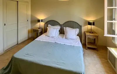 a bedroom with a bed with white sheets and pillows at 2 Bedroom Lovely Home In Saint-Laurent-De-La-Ca in Saint-Laurent-de-la-Cabrerisse