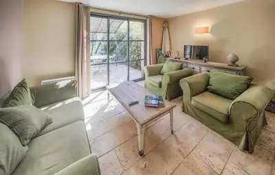 a living room with couches and a table at 2 Bedroom Cozy Home In Saint-Laurent-De-La-Ca in Saint-Laurent-de-la-Cabrerisse
