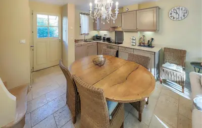 a kitchen with a wooden table and some chairs at 2 Bedroom Awesome Home In Saint-Laurent-De-La-Ca in Saint-Laurent-de-la-Cabrerisse