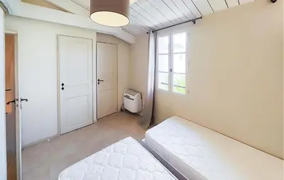 a white room with a bed and a window at 2 Bedroom Gorgeous Home In Saint-Laurent-De-La-Ca in Saint-Laurent-de-la-Cabrerisse
