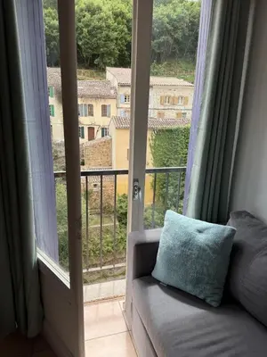 a couch in front of a window with a view at Rennes-les-Bains Studio at Thermal Baths in Rennes-les-Bains