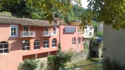 a group of pink buildings in a city at Rennes-les-Bains Studio at Thermal Baths in Rennes-les-Bains