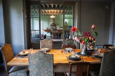 a wooden table with flowers in a dining room at Chateau in medieval Bastide - Sleeps up to 10 in Chalabre