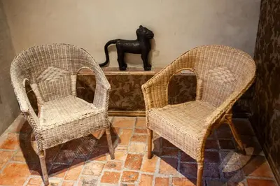 two wicker chairs sitting next to a black cat statue at Chateau in medieval Bastide - Sleeps up to 10 in Chalabre