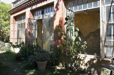 a brick building with a door with a sunflower on it at Chateau in medieval Bastide - Sleeps up to 10 in Chalabre