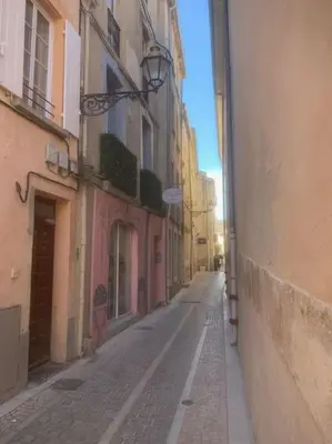 an empty alley with buildings and a street at Grands Buffets hébergement Studio Narbonne in Narbonne