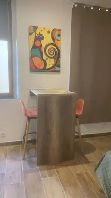 a room with a table and two chairs and a painting at Grands Buffets hébergement Studio Narbonne in Narbonne