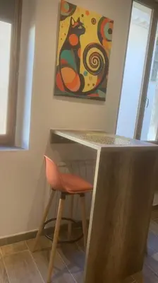 a counter with a chair and a painting on the wall at Grands Buffets hébergement Studio Narbonne in Narbonne